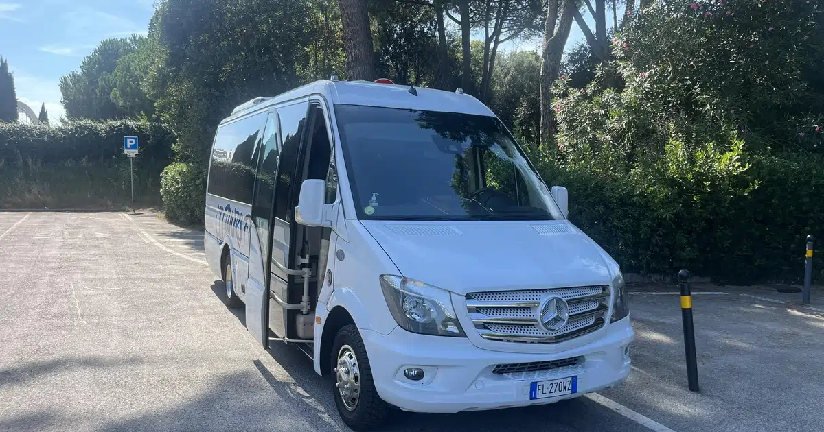 A 16 seats Mercedes Sprinter parked in front of a hotel in Bologna