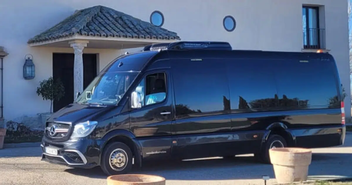 A 19-seater Mercedes Sprinter parked in front of a town house in Madrid